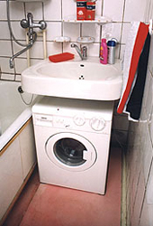 Ванная комната с раковиной над стиральной машиной.